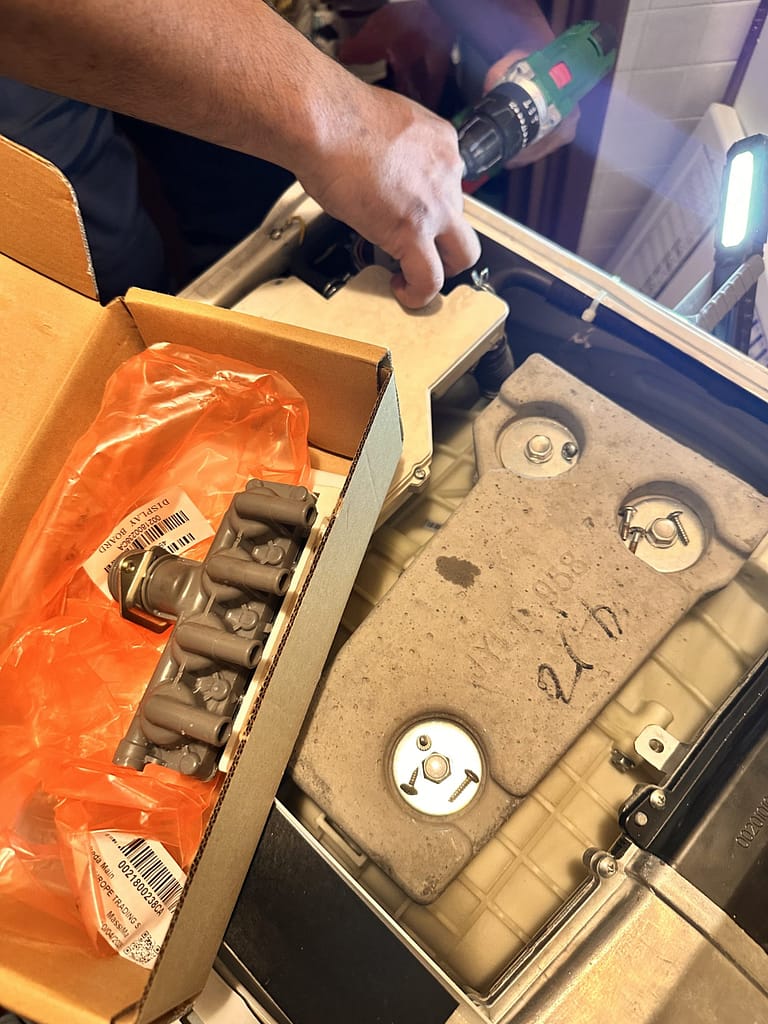 Tecnico DanorAssistance sostituisce un'elettrovalvola originale difettosa su una lavasciuga Haier a Milano.