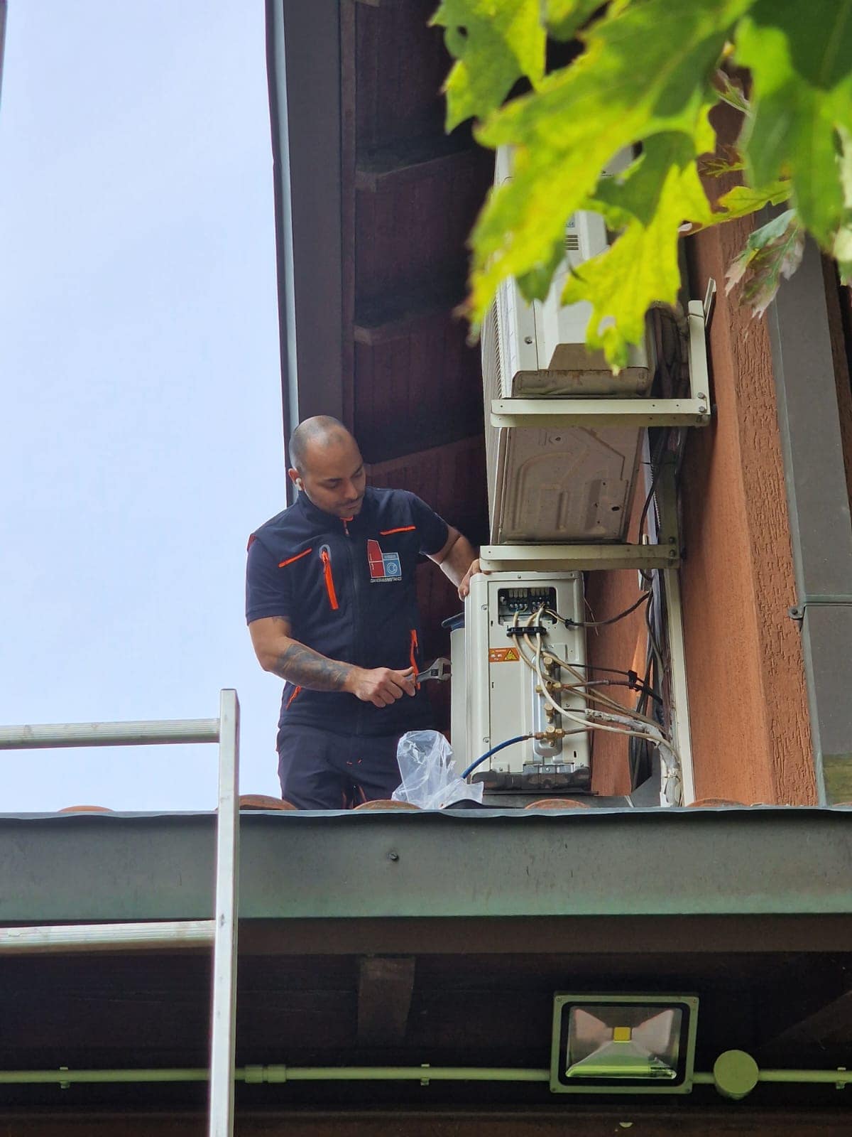 Tecnico Daniele Catania di DanorAssistance installa climatizzatore Daikin sul tetto di un edificio a Milano.
